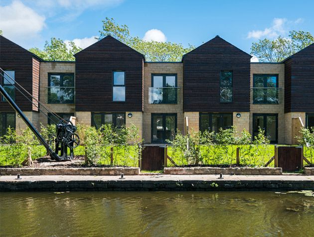 Waterside modern homes in brown cladding blue sky
