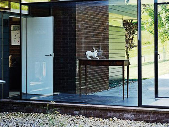glass walkway exterior gravel white rabbit ornament on wooden table white door 