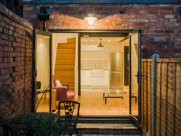 a rear extension on a small house with the lights on at night 