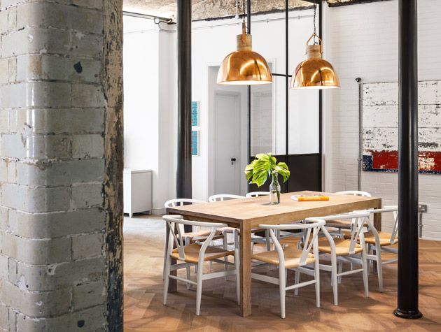 the kitchen area of a renovated old warehouse with exposed cement pillars