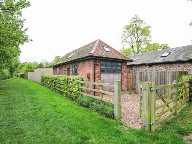 non residential property conversion into small red brick house surrounded by greenery