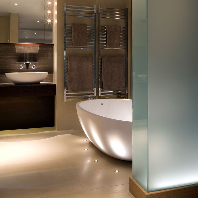 Bathroom with internally lit dividing wall and led floor lights by Brilliant Lighting