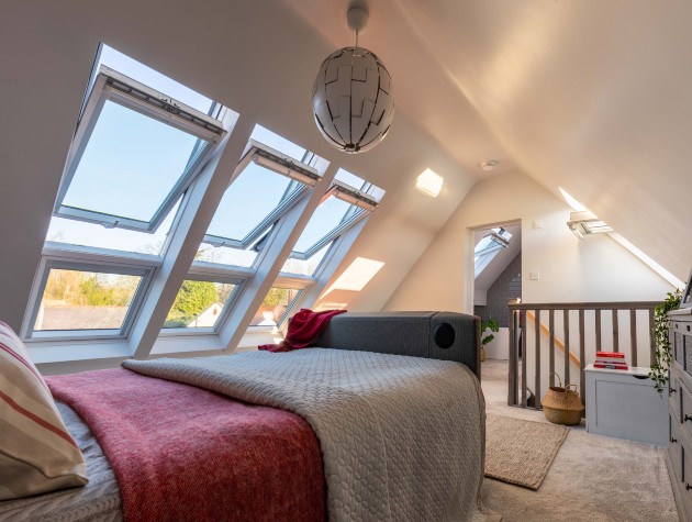 bed in converted loft next to velux windows