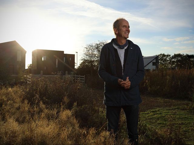 kevin mccloud standing in a field at sunrise or sunset for Grand Designs The Street on Channel 4