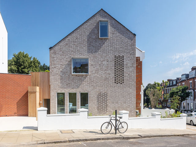 grey and red brick end of terrace house exterior original design with bike
