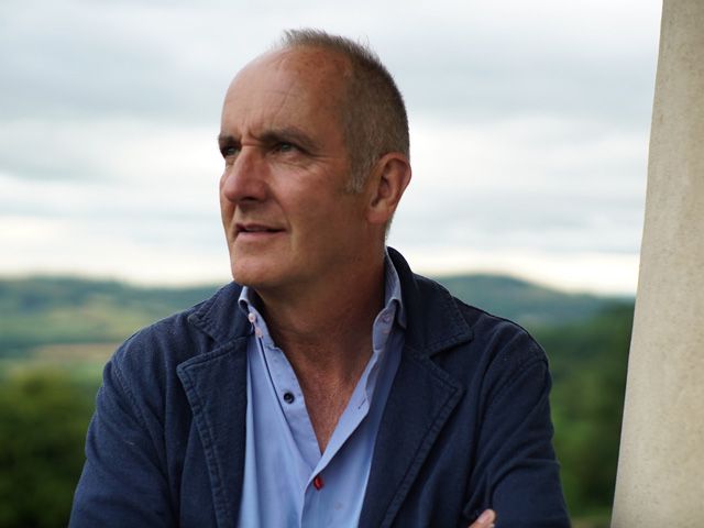 Kevin McCloud looking into distance in the countryside, hosting Kevin's Grandest Designs tv show set to air on August 28th 2019