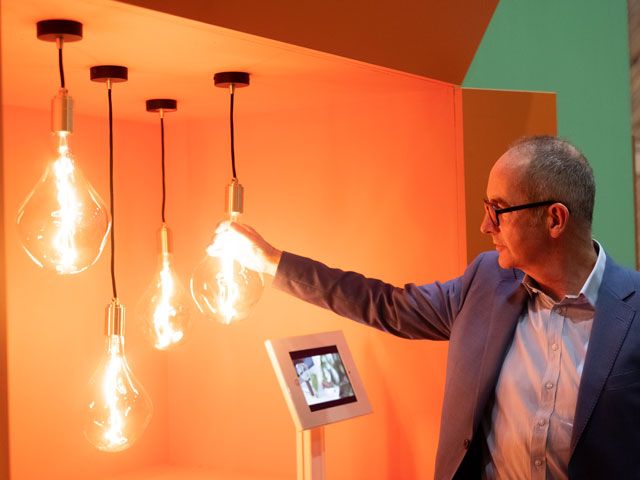 kevin mccloud looking and touching lighting at his green heroes at grand designs live