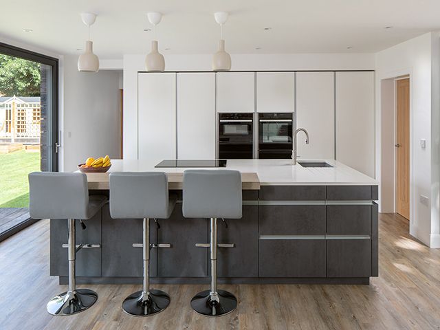 modern kitchen in white and grey with large island and bar stools