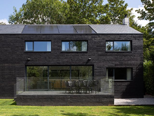 Charred timber barn-style home in Wiltshire with raised terrace