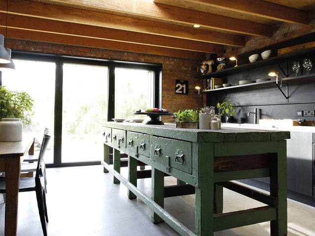 reclaimed freestanding island in a period home extension with beamed ceiling