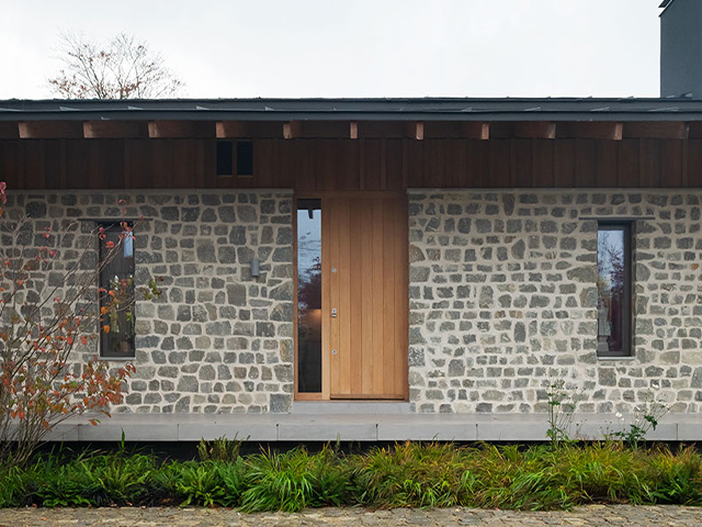 stone house with wooden door - 7 striking stone houses - self build homes - granddesignsmagazine.com