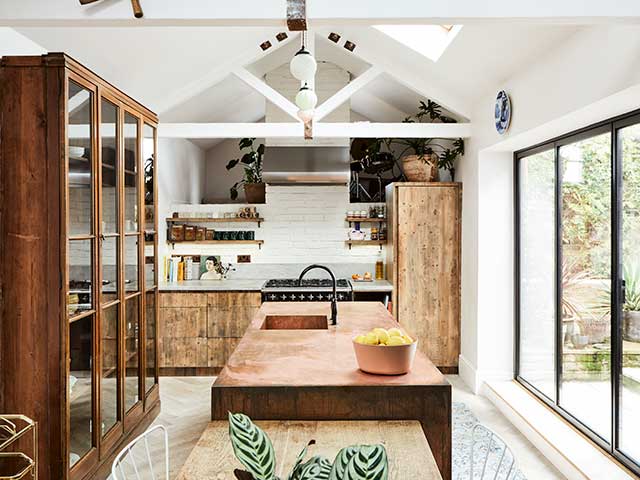 Kitchen with wooden counter and wooden units with white sloping ceilings