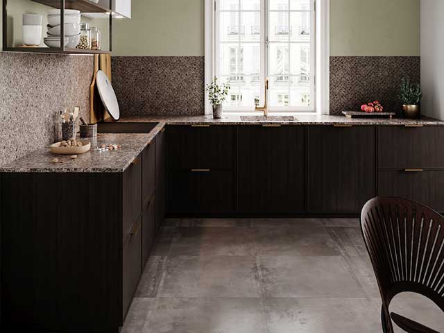 Natural stone worksurface with grey slate flooring and big white windows