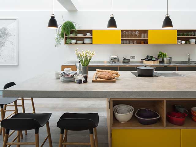 Concrete worksurface in kitchen with pops of yellow and green accessories