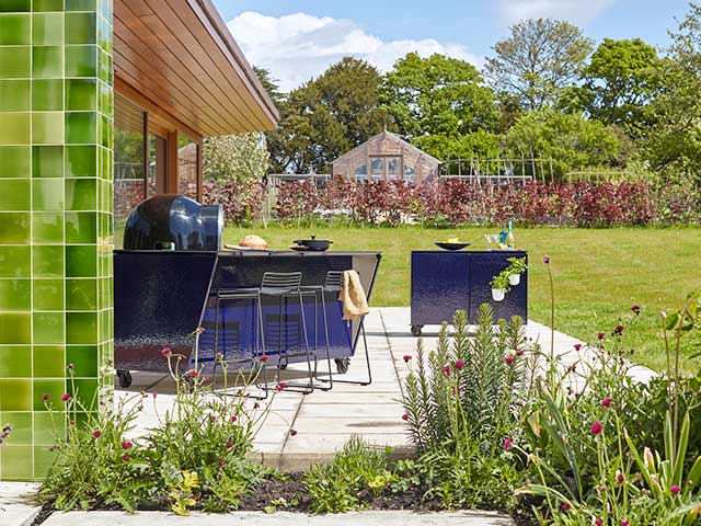Outdoor kitchen with green tiles and plants