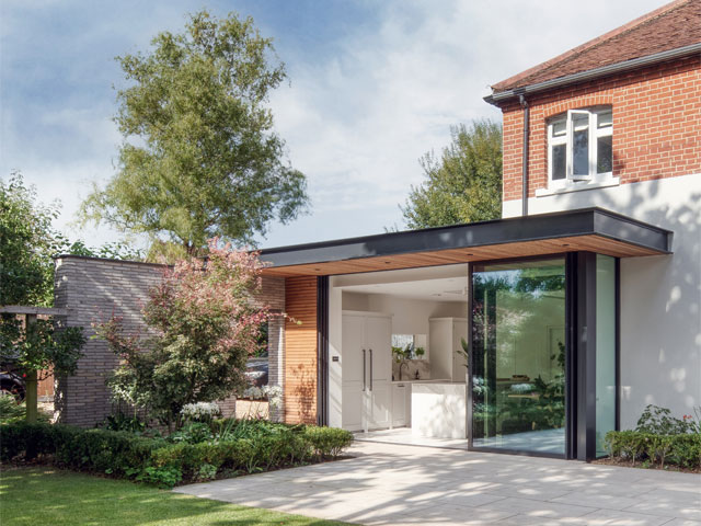 black trimmed patio wraparound extension white kitchen small hedges stone patio flooring