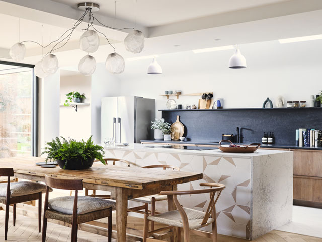 kitchen lighting ideas - feature light above a dining table, pendant light above a kitchen island and skylights above the sink