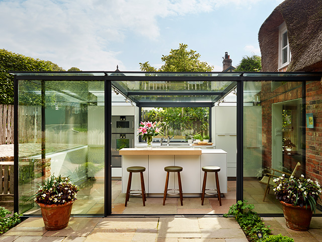 thatched cottage with glass box indoor outdoor extension 