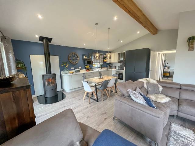 affordable kit house interior with wood-burning stove and open-plan kitchen diner