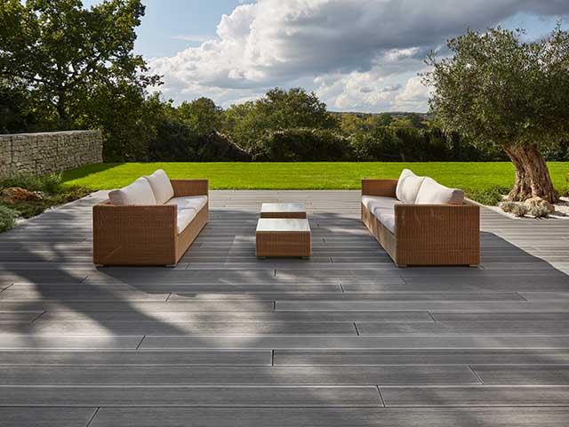 grooved surface deck boards made with wood and resin with rattan sofas on top