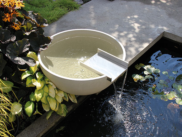 scupper mains-powered water feature pouring into a pond