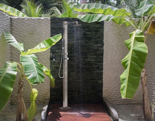 Outdoor shower with leafy trees surrounding in privacy area