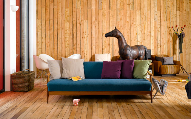 Interior of the living area in the Grand Designs Lake District house with timber clad walls and wooden floorboards