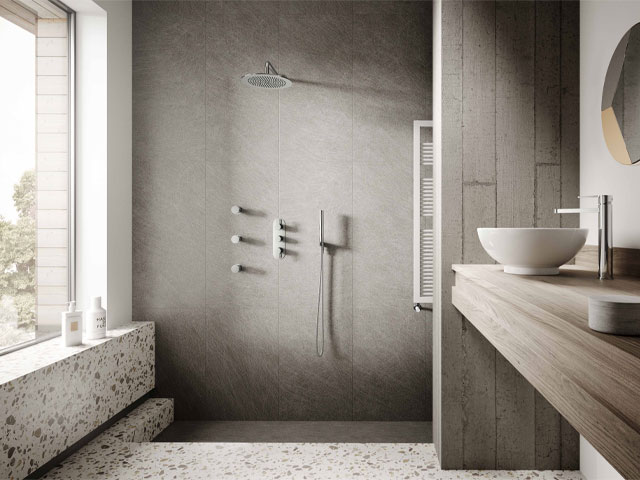 wet room with sunken shower area in natural stone colours with terrazzo floor 