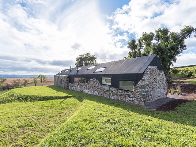 The exterior of a new home built inside the shell of a ruined farmhouse