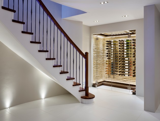 room with staircase leading upstairs and walk in wine storage