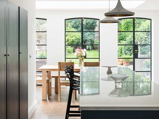 Kitchen rear extensions with full size glass windows and island with wooden table