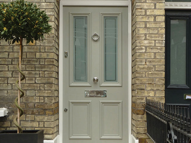 Victorian style front door in bespoke design with brickwork walls beside