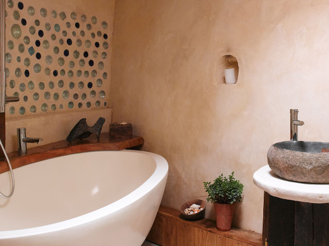 Stone resin bath by a curved wall in Grand Designs earthship house