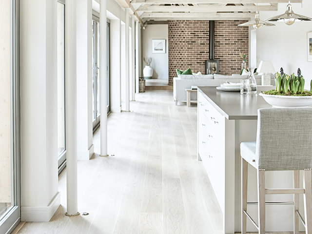 modern country kitchen diner and living space painted white with exposed brick wall and floor-to-ceiling windows