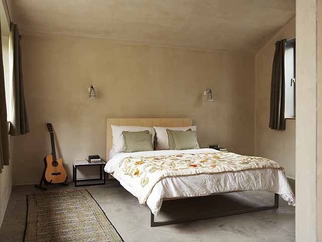 Bedroom with polished plaster walls and a concrete floor