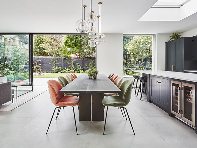 dining area with colourful upholstered chairs and bifold doors leading out to garden