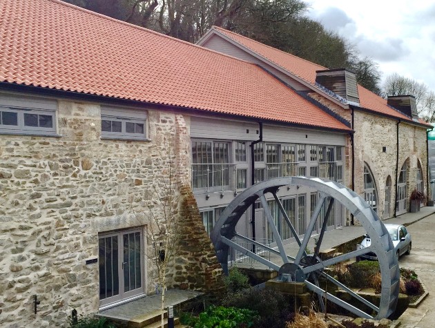Exterior view of Hammer Mills converted industrial buildings and water wheel by Waterhouse Architects