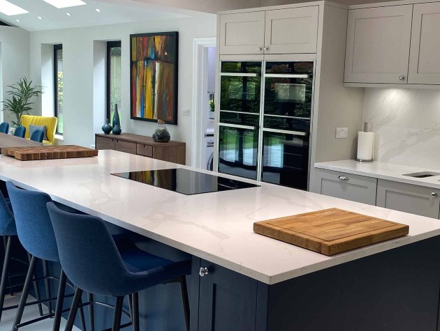 Kitchen extension featuring Masterclass Kitchens Shaker style wood grained kitchen with grey peripheral units and blue kitchen island