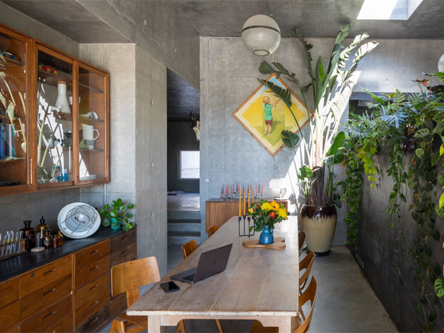 a modern grey kitchen with teak-coloured cabinets and ercol-style dining chairs