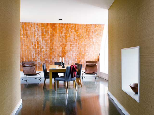 Sloping wall with brickwork in dining room of Grand Designs eco arch