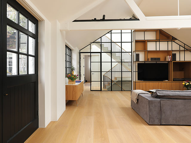 Open plan living space with glass wall and oak joinery in steel grid pattern