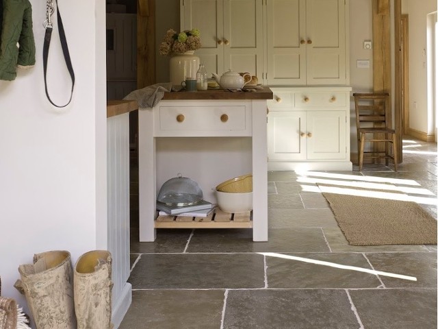 stone flagstone flooring in a country cottage kitchen with white cabinets