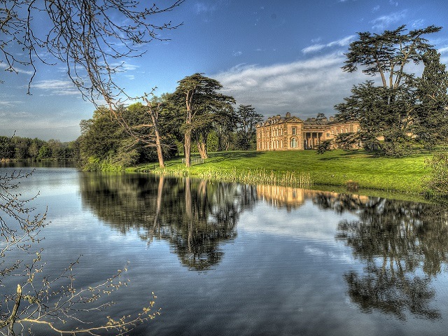 beautiful country manor in the English countryside next to a calm, still lake