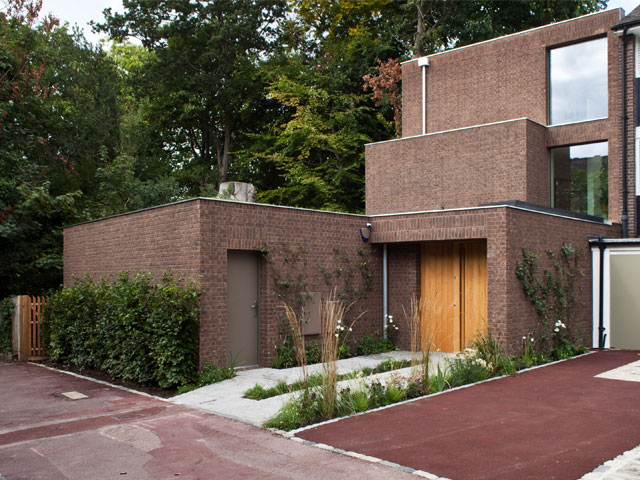 difficult plots. Red brick home exterioe end of terrace wooden garage door surrounding woodland