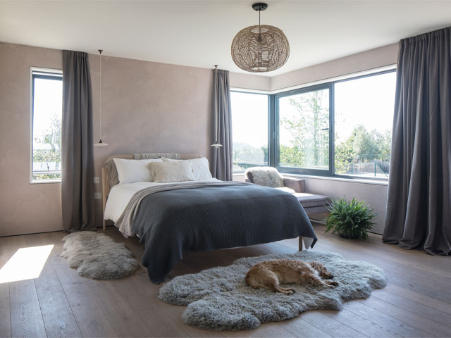 Bedroom with neutral palette, rattan and sheepskin rugs