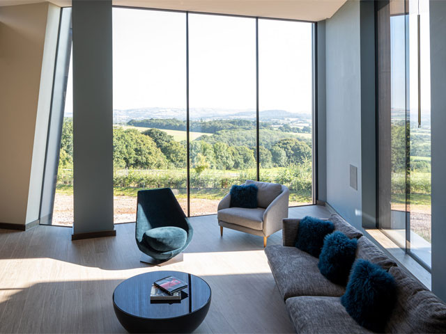 Inside Hux Shard in Exeter: the living room with huge windows and views over the countryside