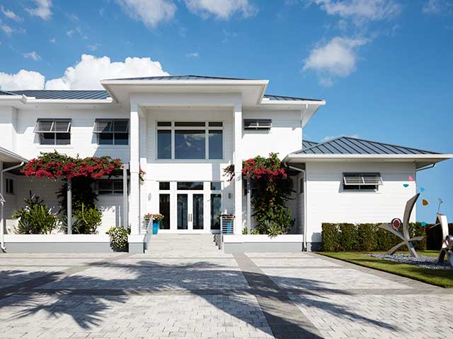 Florida villa outside with white walls, plants and dark ceilings