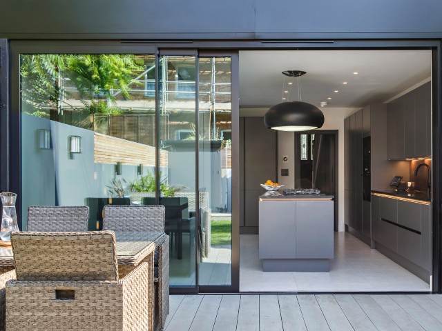 Courtyard with grey panelled flooring looking into kitchen space