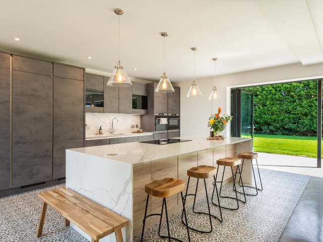 modern open-plan kitchen with large kitchen island and bi-fold doors out onto the garden