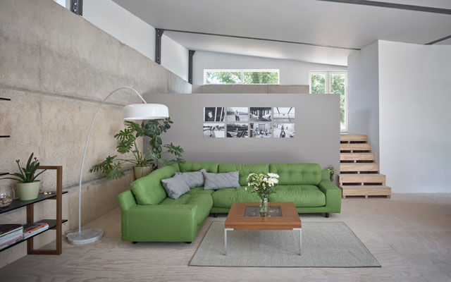 View of open plan living room with concrete walls and floor